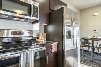 Kitchen with matching stainless steel appliances and dark finish cabinets at The Villas at Mahoney Park in Northeast Lincoln, Nebraska