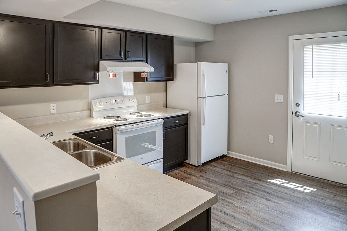 a kitchen with white appliances and black cabinets