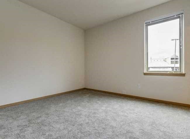 an empty room with a window and a carpet