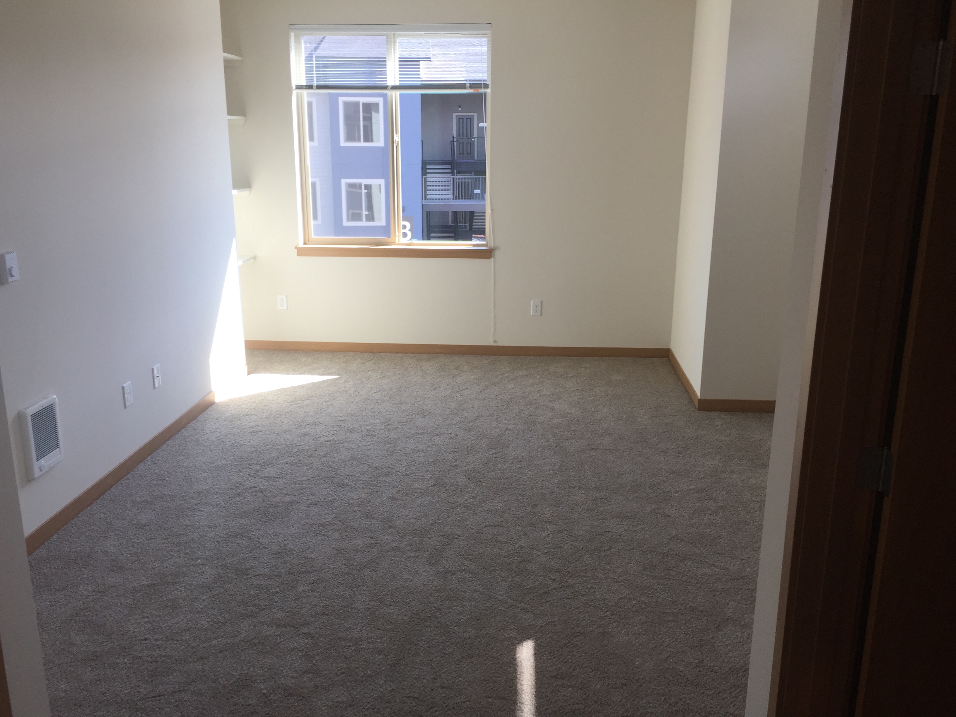 an empty room with carpet and a window