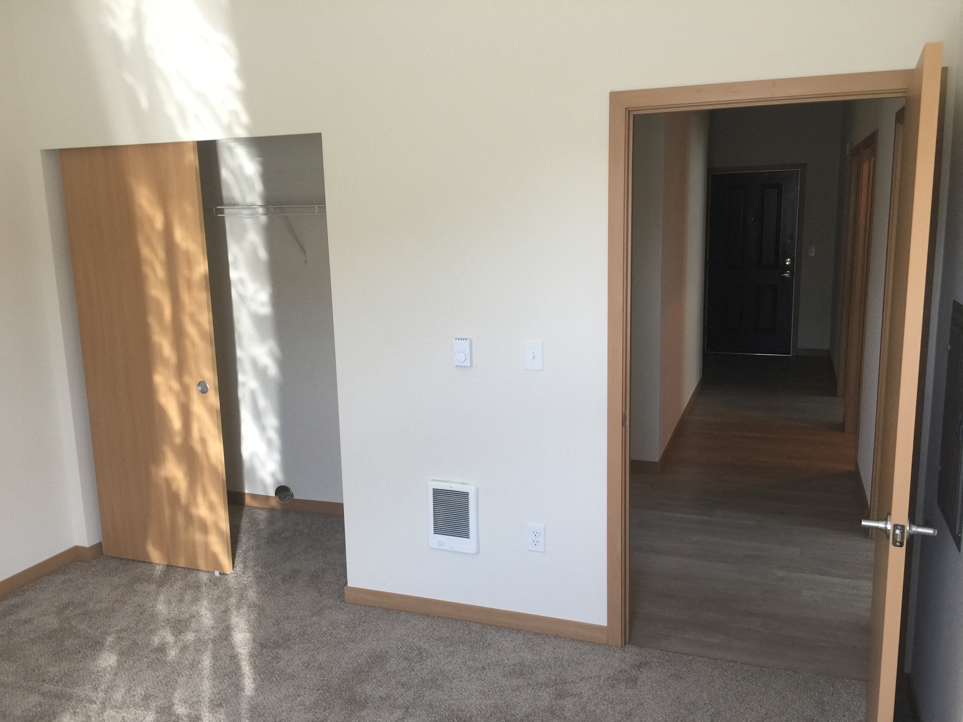 an open door in a room with a hallway and a door to a closet