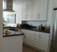 a kitchen with white cabinets and a black counter top