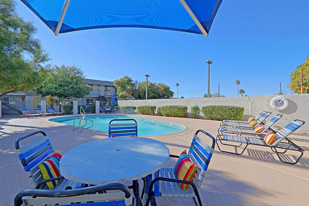 our apartments have a pool and patio with chairs and tables