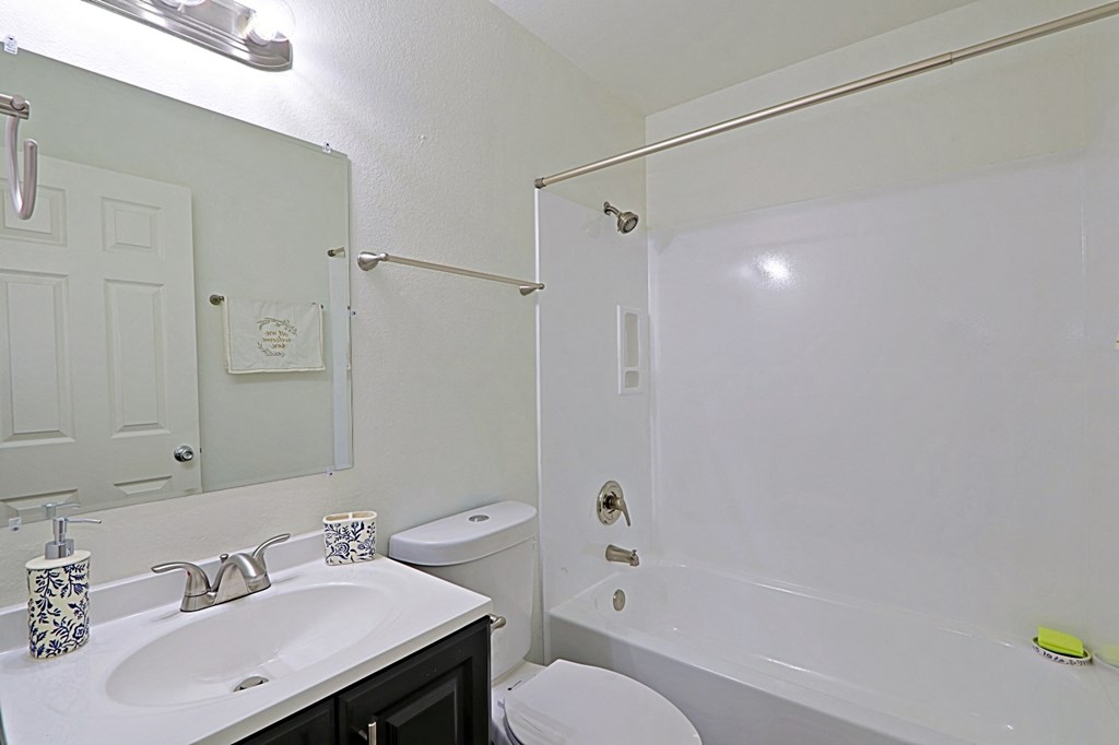 a bathroom with a shower sink and toilet and a mirror