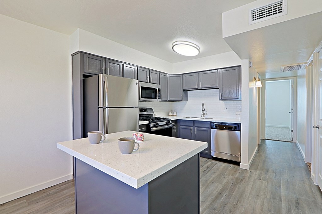 a kitchen with stainless steel appliances and white countertops