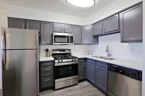 a kitchen with stainless steel appliances and black and white cabinets