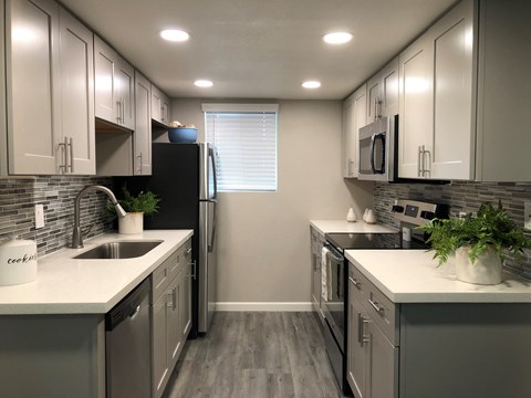 a kitchen with stainless steel appliances and white counter tops