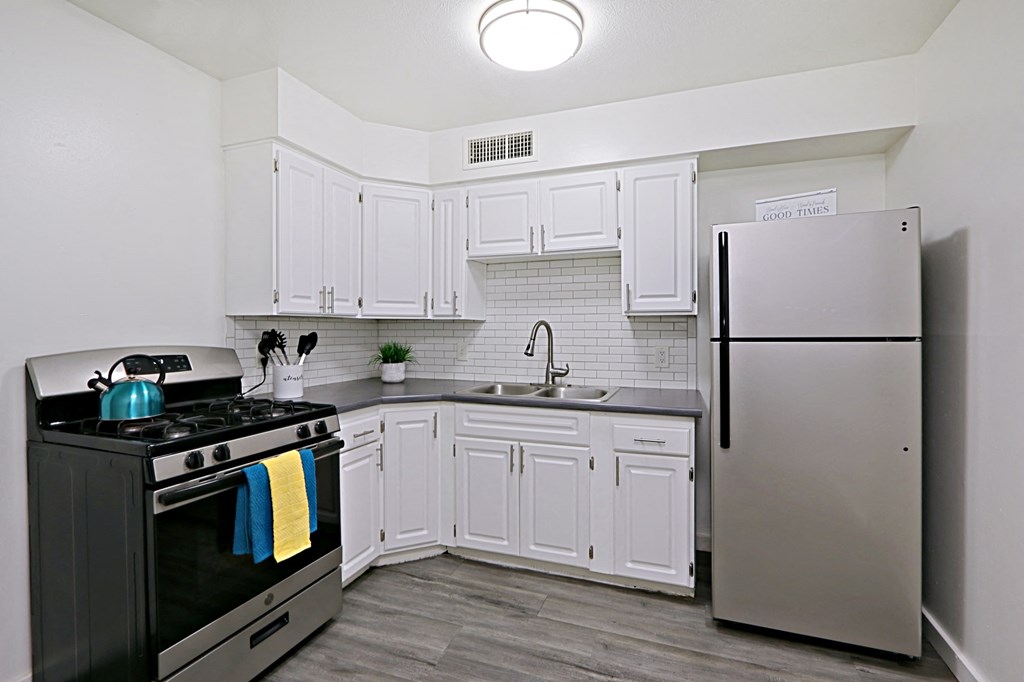 a kitchen with stainless steel appliances and white cabinets