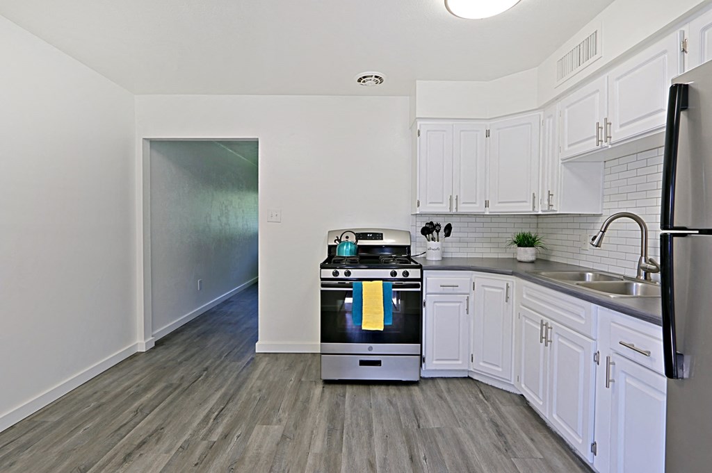 a renovated kitchen with white cabinets and stainless steel appliances