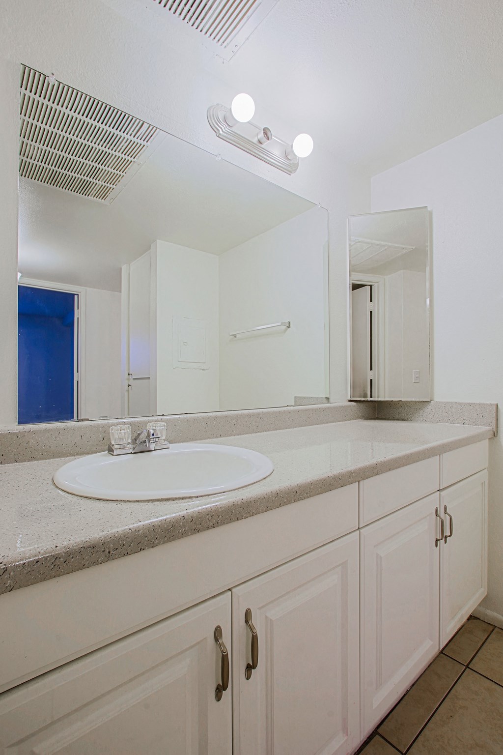 a white bathroom with a sink and a mirror