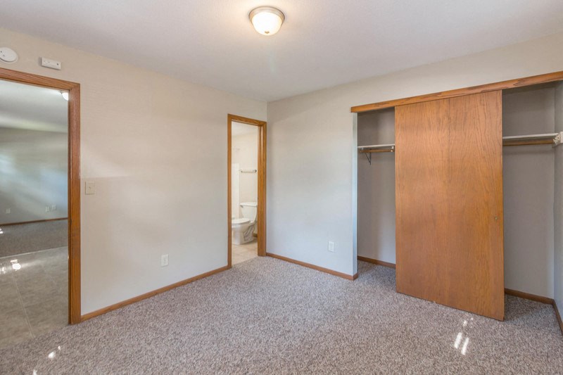 an empty bedroom with a closet and a bathroom