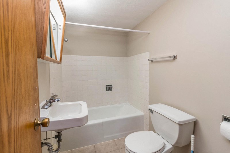 a bathroom with a toilet and a sink and a bath tub