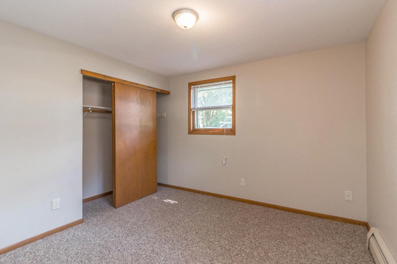 an empty living room with a door to a closet