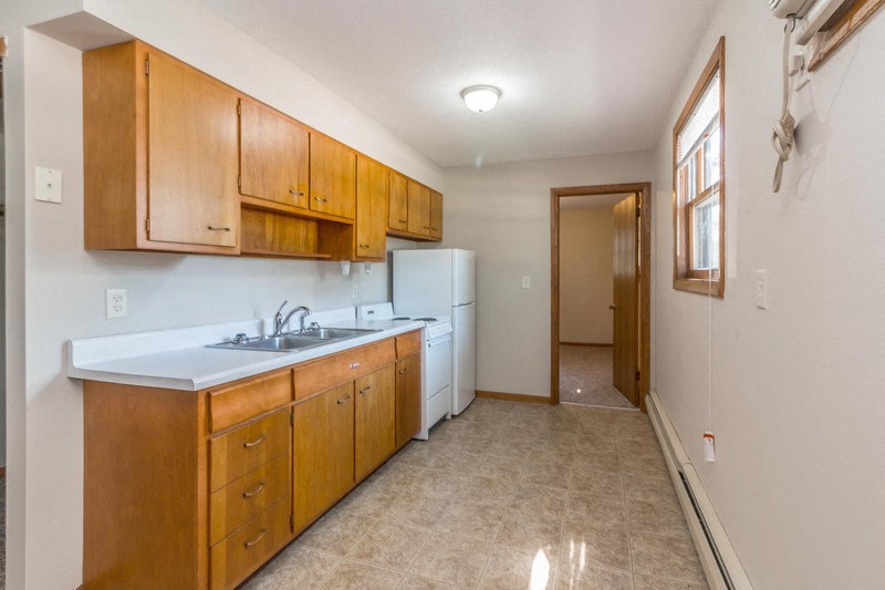 a kitchen with wooden cabinets and a white refrigerator