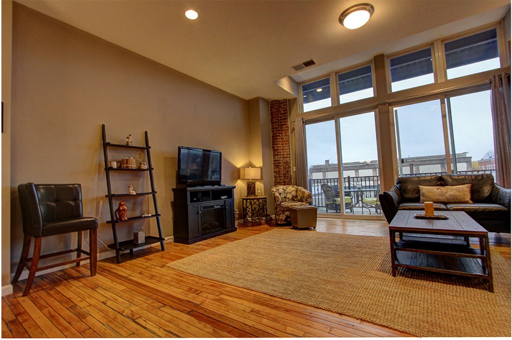 a living room with a large window and a wooden floor