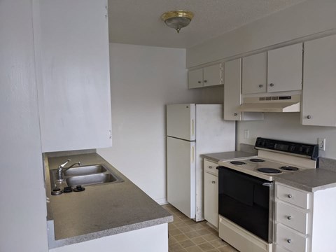 A kitchen with white appliances and cabinets.