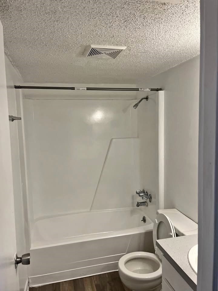 A white bathroom with a toilet, sink, and bathtub.