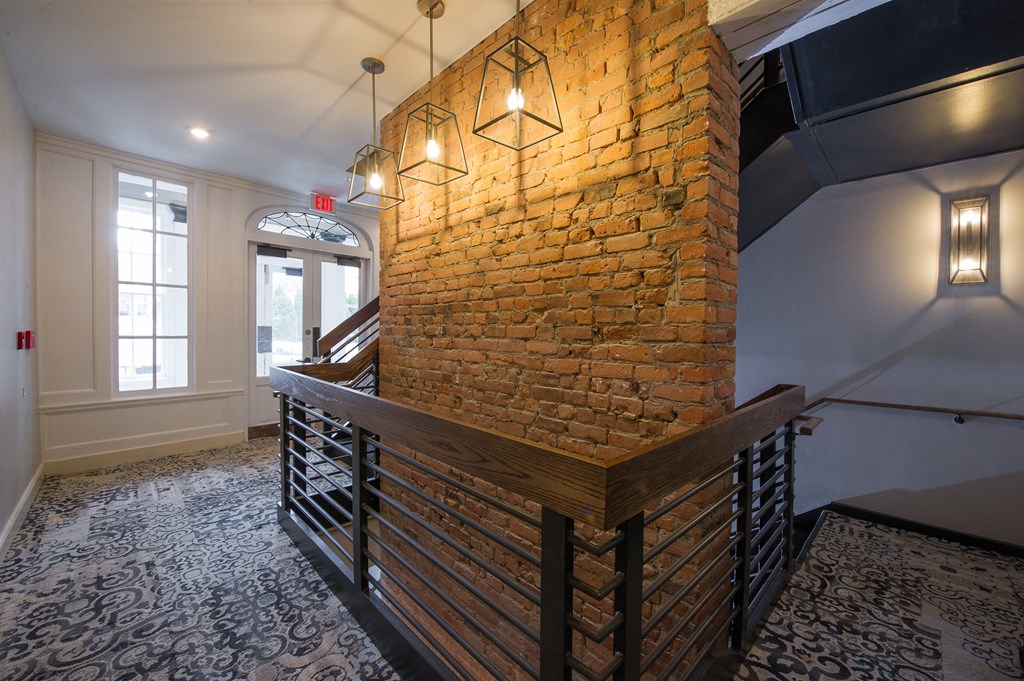 a large brick wall in a stairwell with two lights on it