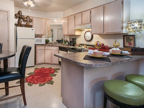 a kitchen with a breakfast bar and a table with chairs