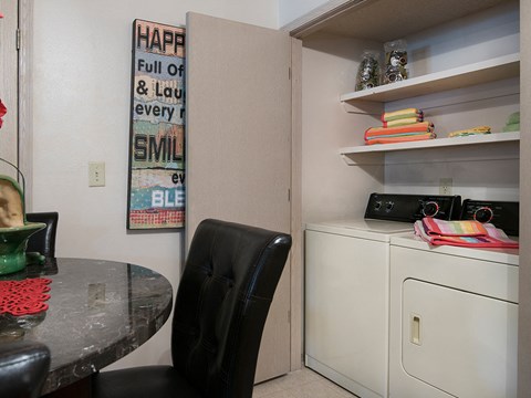 a laundry room and dining room with a table and a sink