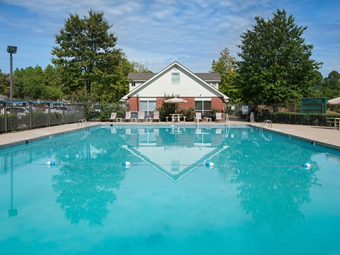 a swimming pool with a house in the background