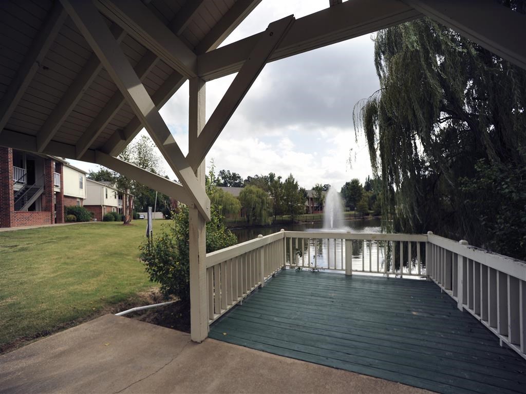 a deck with a fountain in a pond