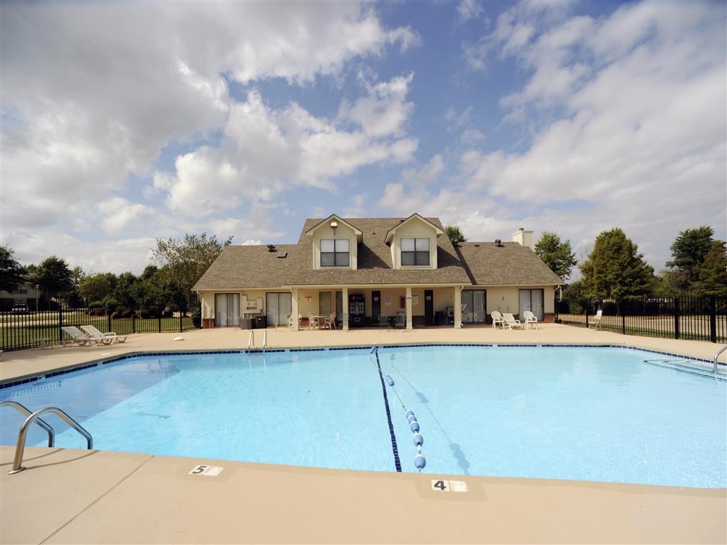 a swimming pool with a house in the background