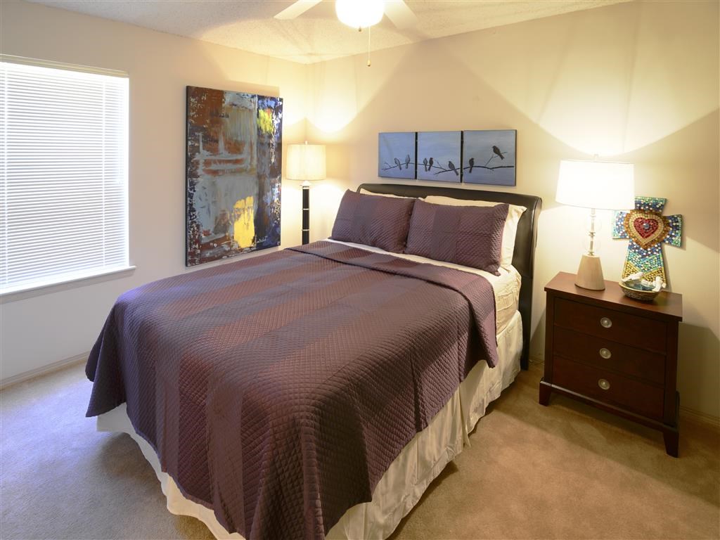 a bedroom with a bed and a night stand