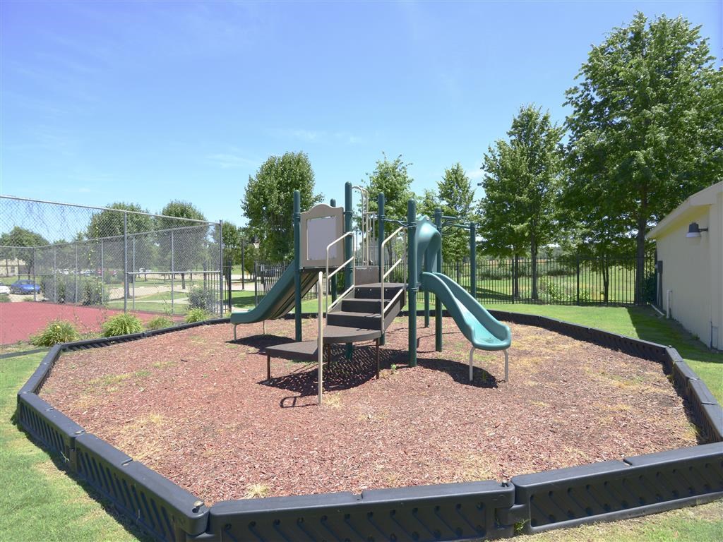 a playground with slides and chairs in a park