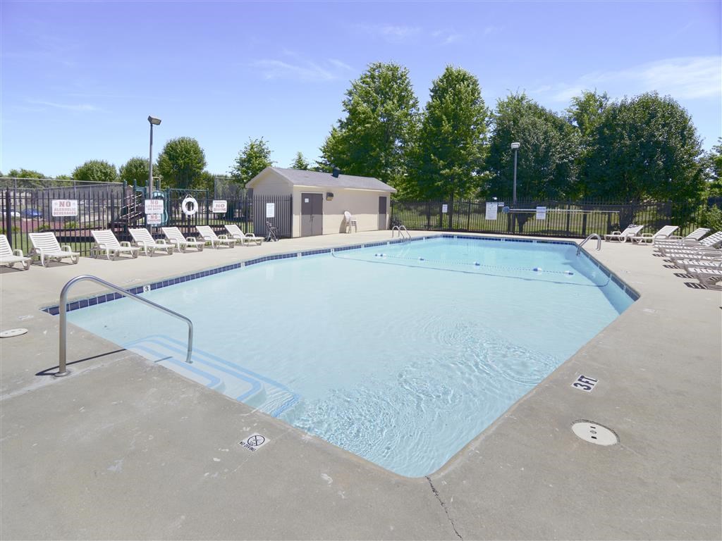 a resort style pool with chairs around it and trees