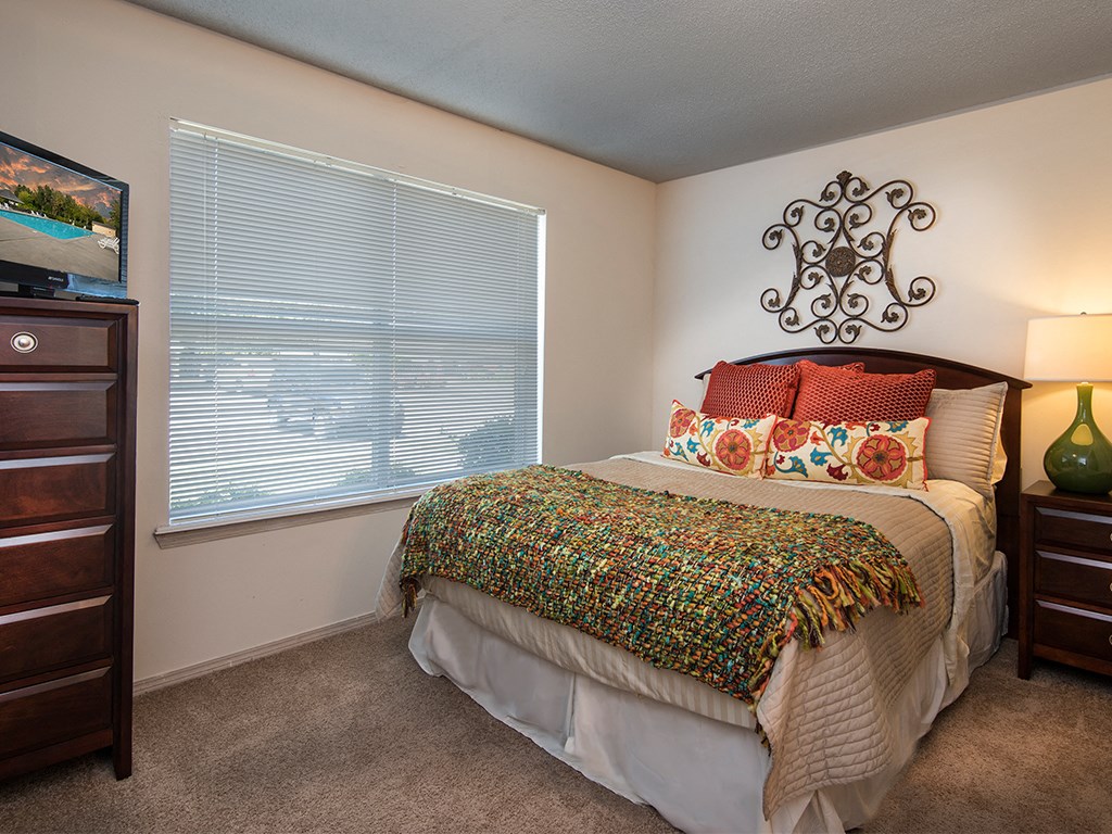 a bedroom with a bed and a large window