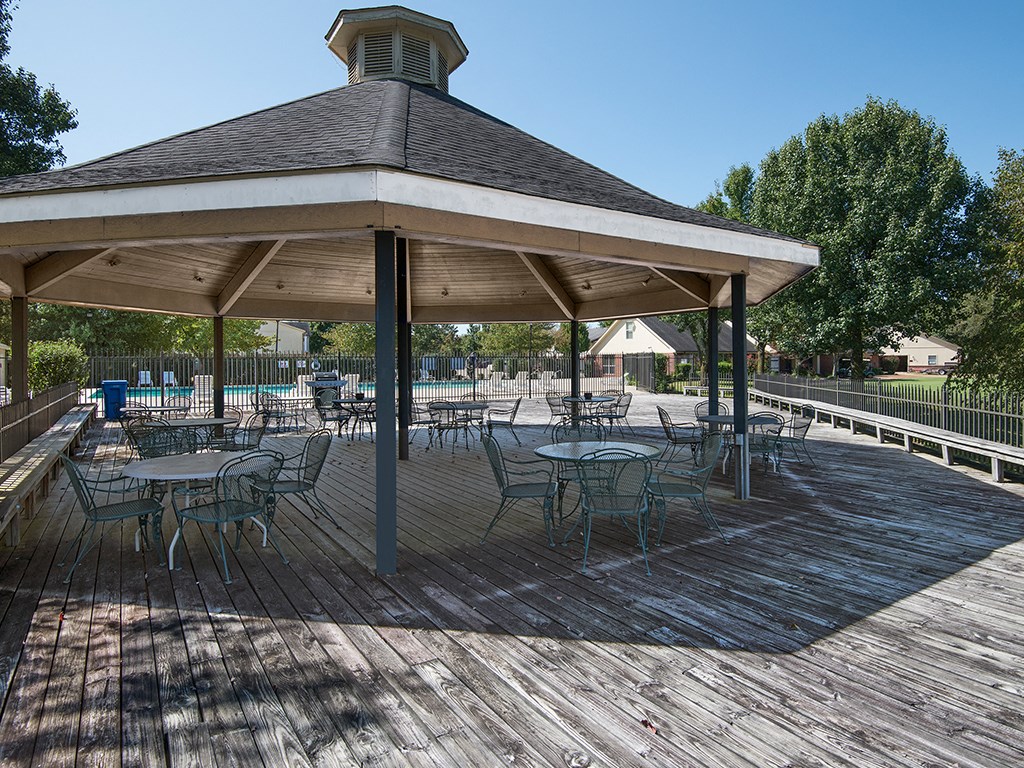 a picnic area with tables and chairs under a pavilion