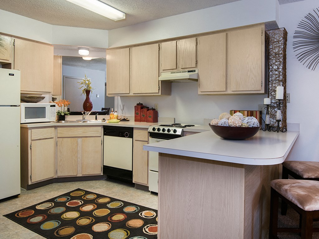 a kitchen with white appliances and a counter with a bowl of cookies