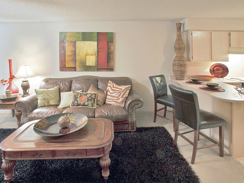 a living room and kitchen with a couch and a table