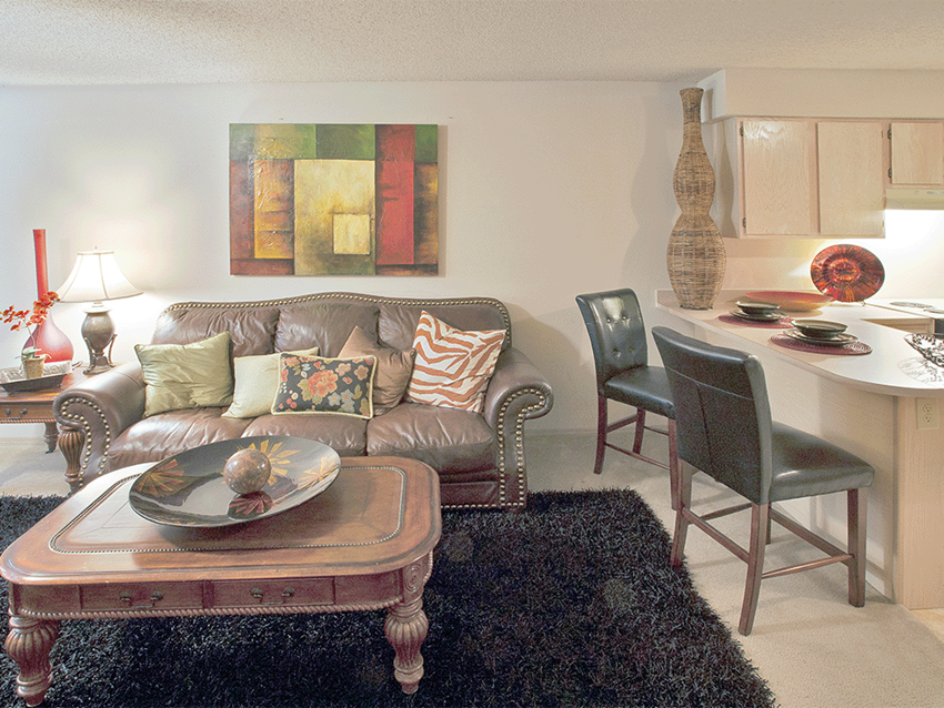 a living room and kitchen with a couch and a table