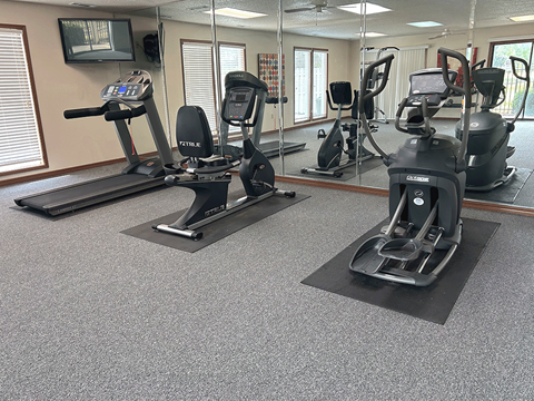 a gym with exercise machines and mirrors in a building