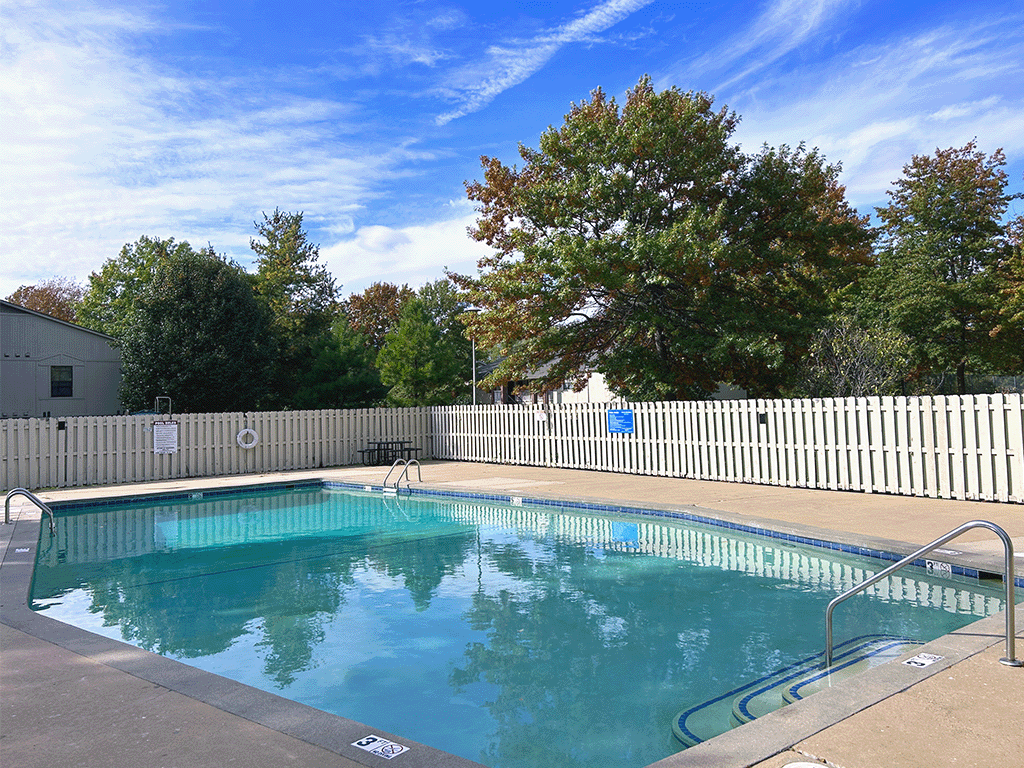 a swimming pool with a white fence around it