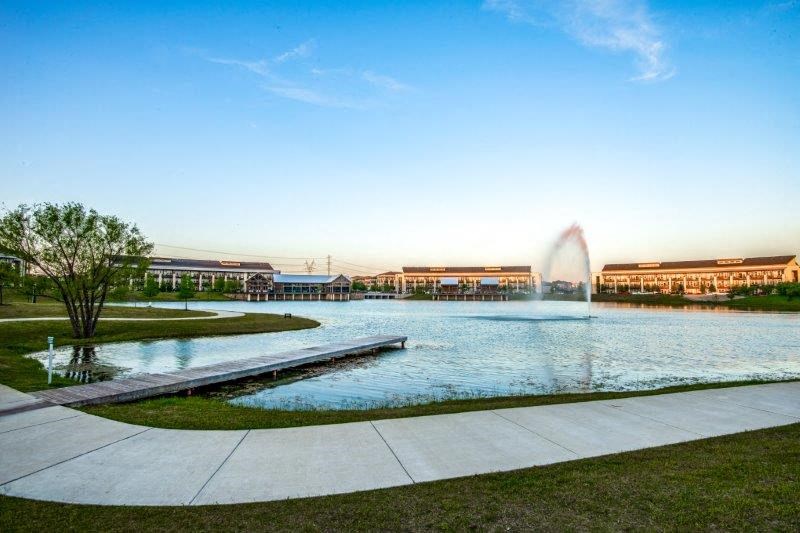 a fountain in a pond with a building in the background
