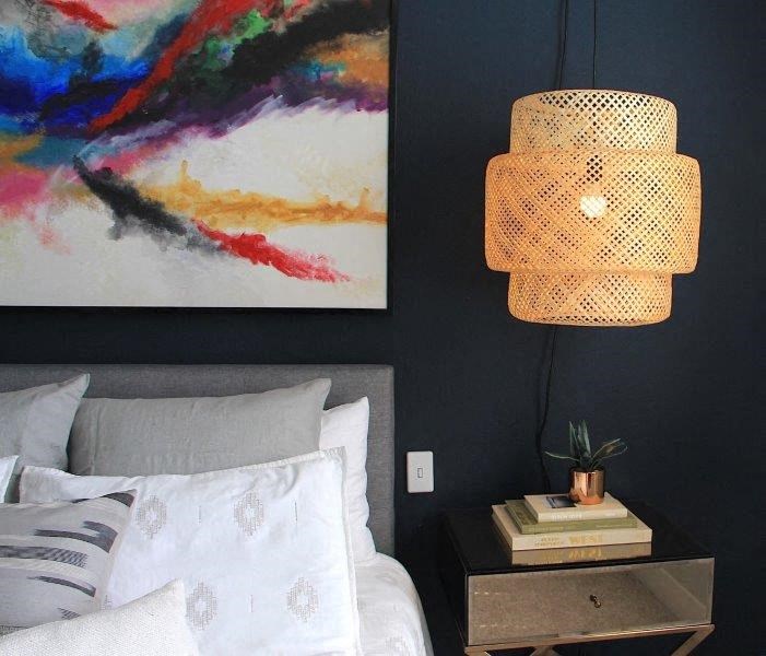 a bedroom with a bed and a lamp and a painting