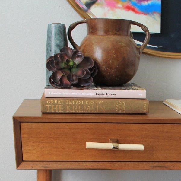 a vase sitting on top of two books on a table