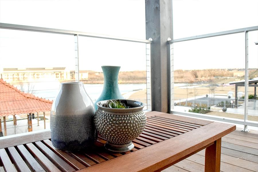 two vases sitting on a wooden table on a balcony