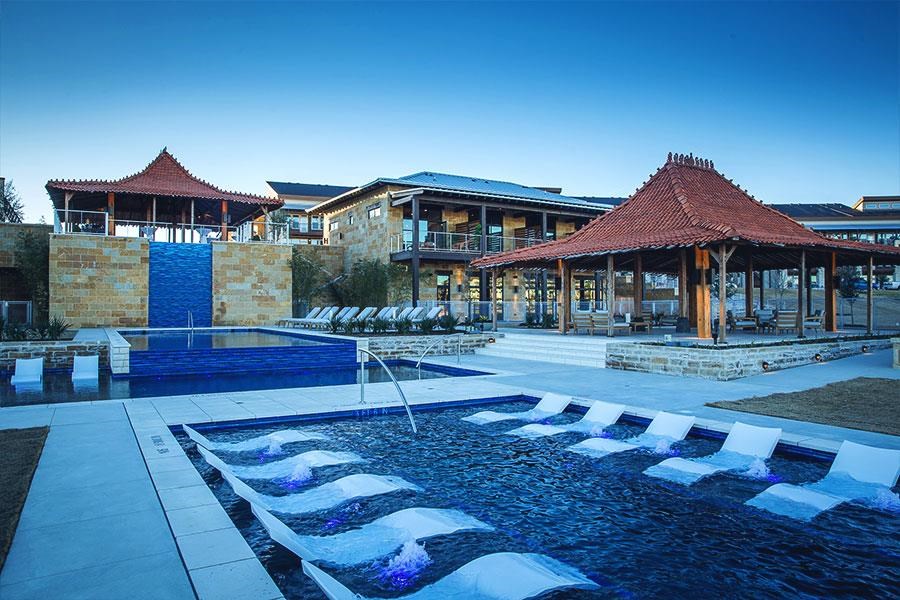 a swimming pool with chairs in front of a resort