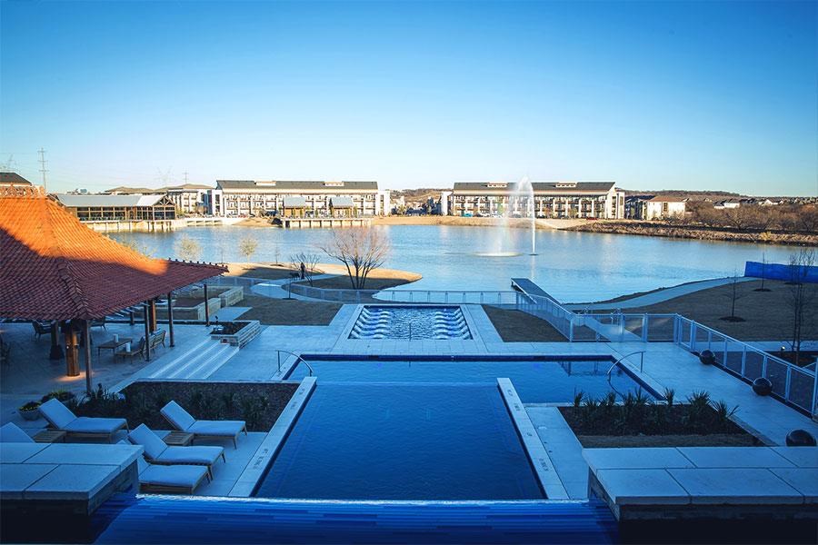 an aerial view of a lake with a swimming pool and a fountain