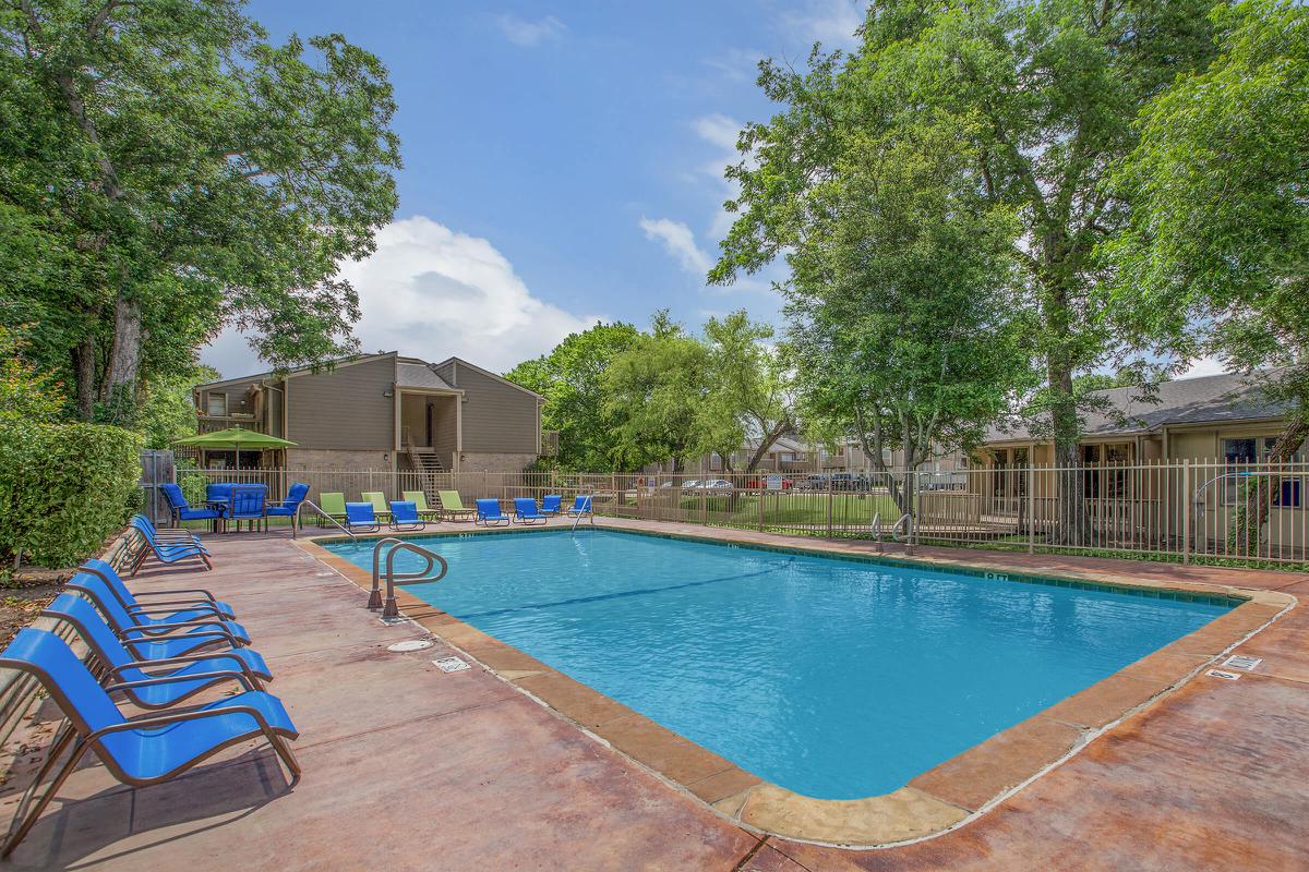 a swimming pool with blue chairs around it