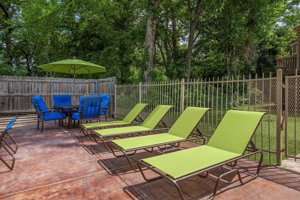 a group of lawn chairs and umbrellas on a patio
