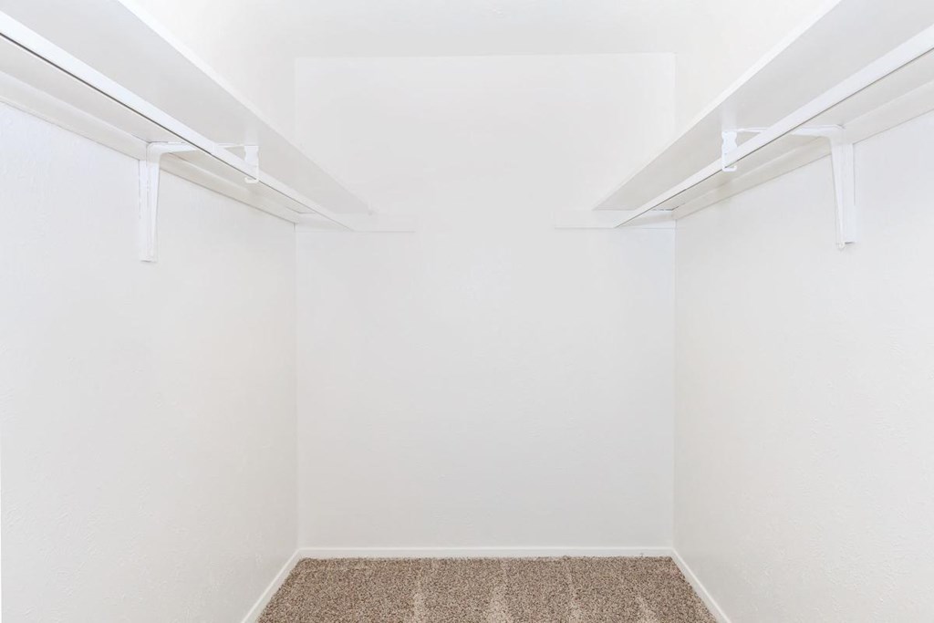 an empty room with white walls and a carpet