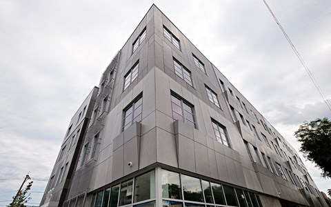 a tall grey building with windows on the side of it