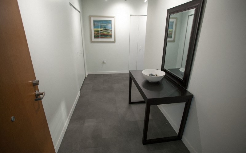 a bathroom with a vanity with a mirror and a door