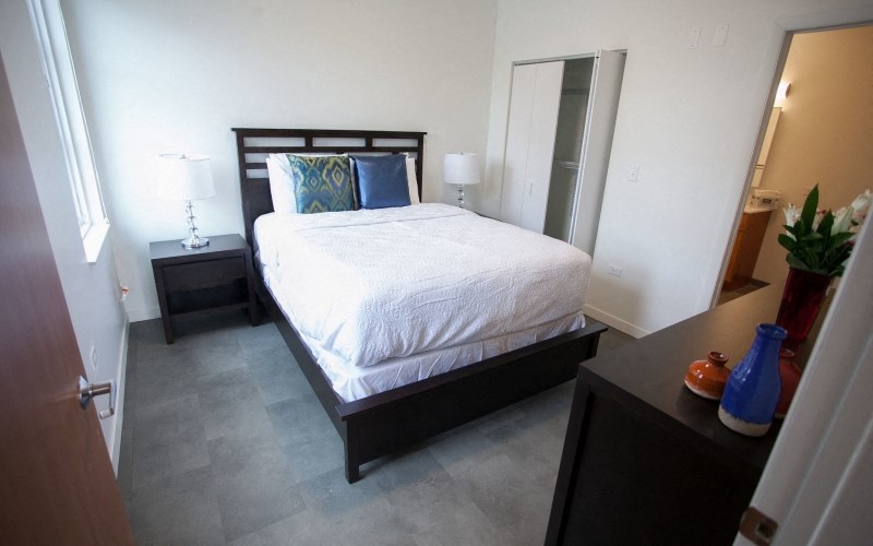 a bedroom with a bed and a dresser and a closet