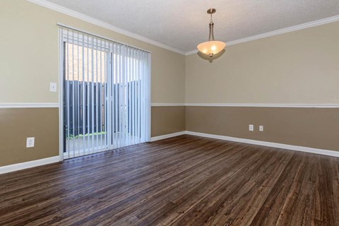 an empty living room with wood flooring and a sliding glass door